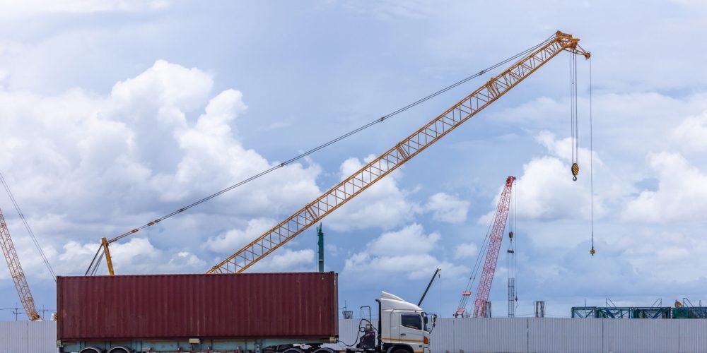 Construction site with construction crawler cranes and multi storey unfinished buildings, Many high rise cranes and industrial construction equipment, Contruction site blue sky background.